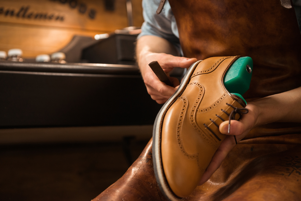 Shoemaker in workshop making shoes.